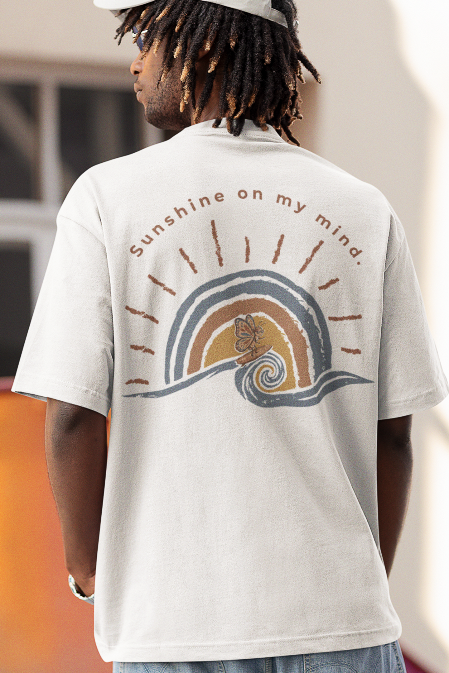 Person wearing white Sunshine On My Mind butterfly shirt with oversized retro butterfly and wave back print on the back