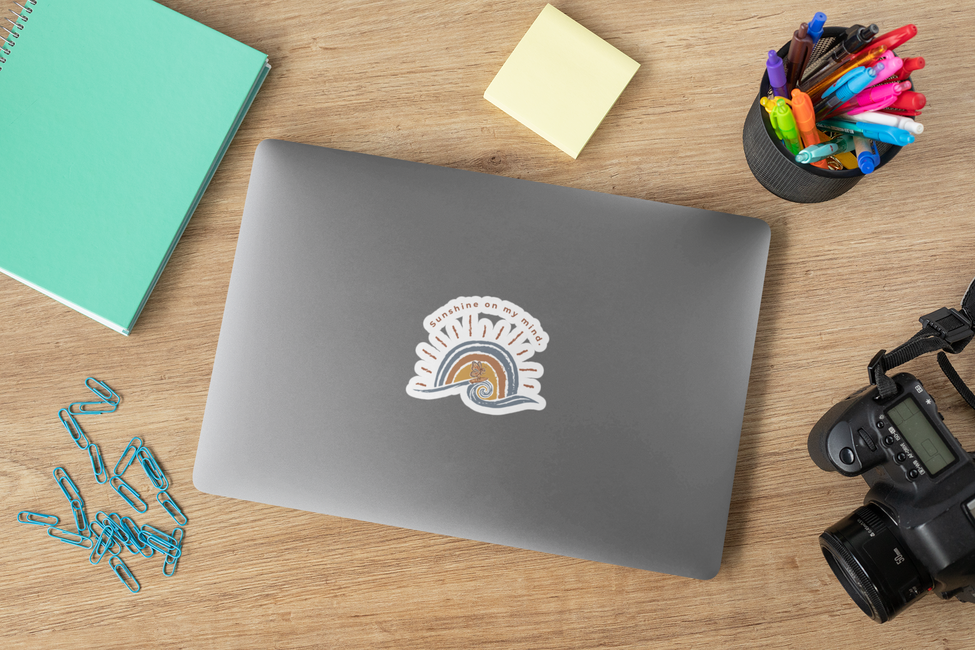 Sunshine On My Mind butterfly sticker on laptop placed on desk with stationery accessories