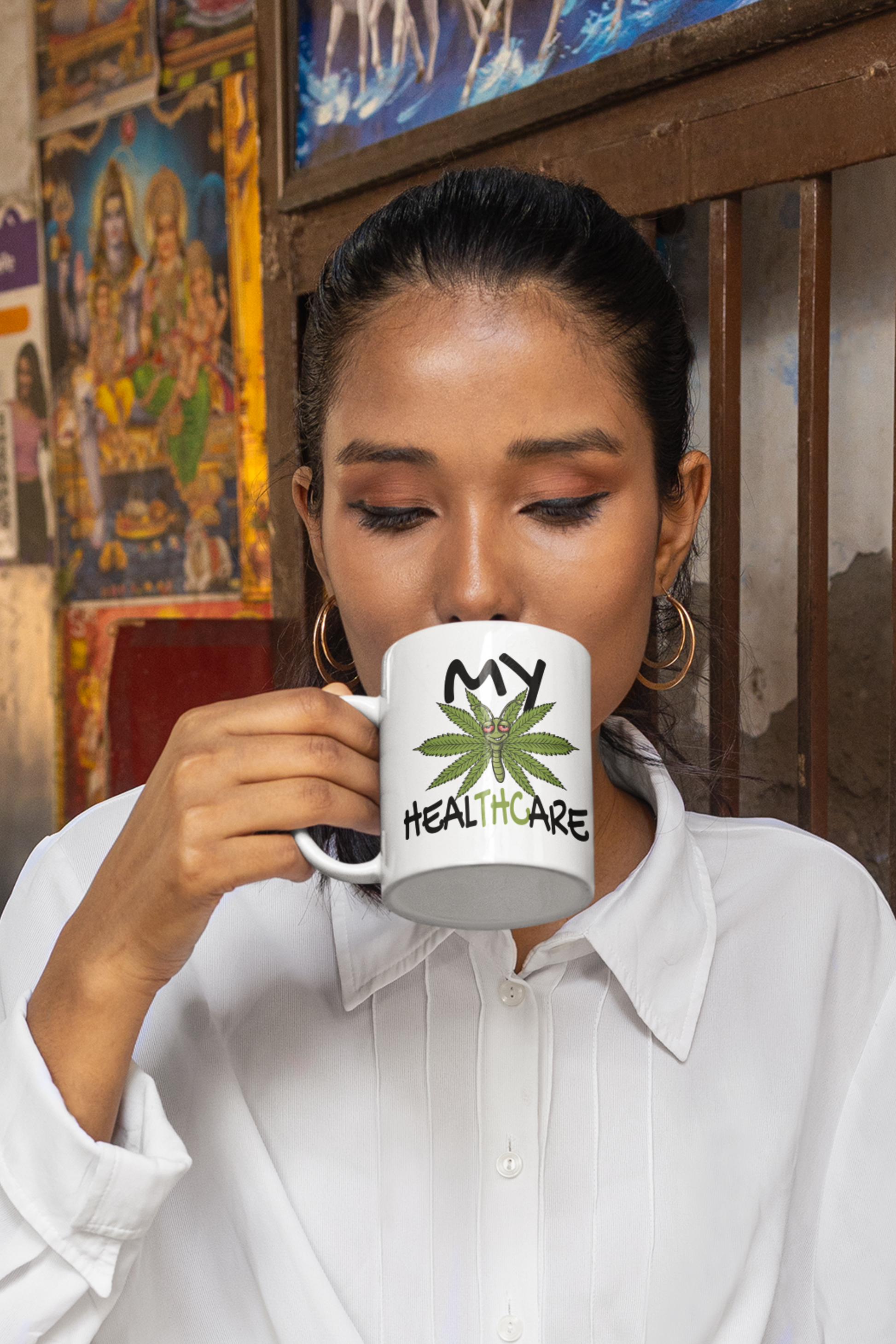 Woman drinking from a My Healthcare cannabis butterfly coffee mug with a funny THC weed design for 420 fans and marijuana humor lovers.