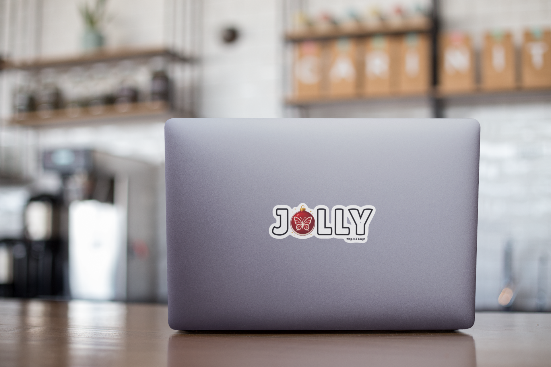 Laptop with a Jolly holiday sticker on a blurred cafe background